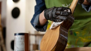 Carpintero barnizando un instrumento musical