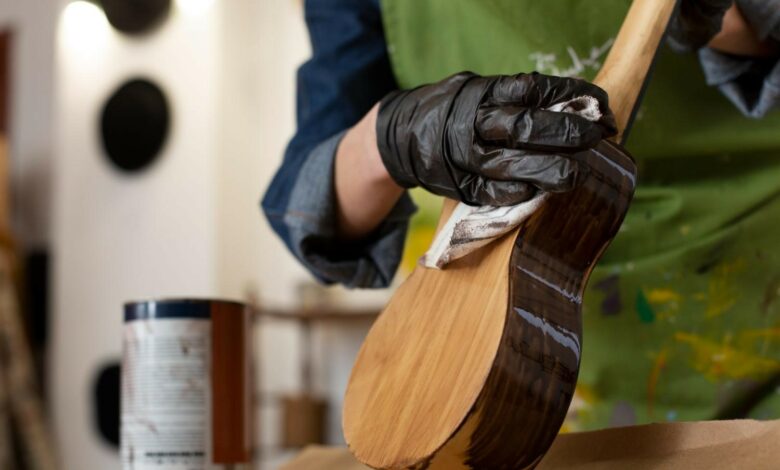 Carpintero barnizando un instrumento musical